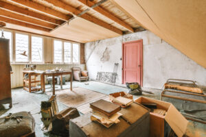 A room with a table and chairs and a red door.